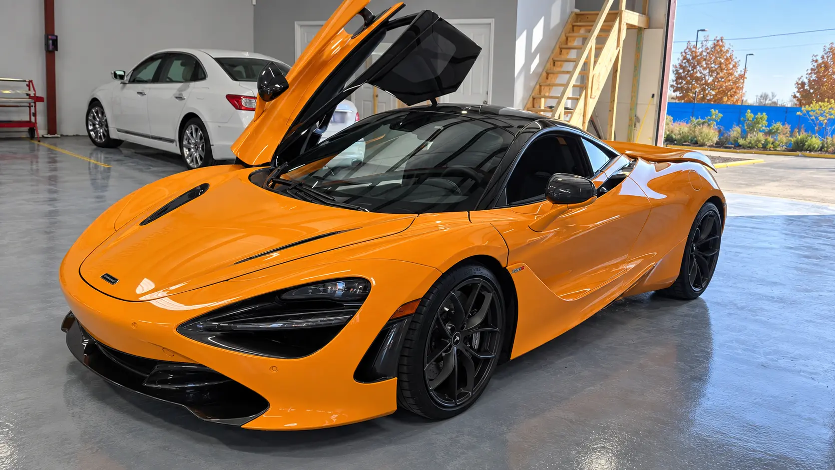 Orange McLaren with its doors raised inside the Rayco shop