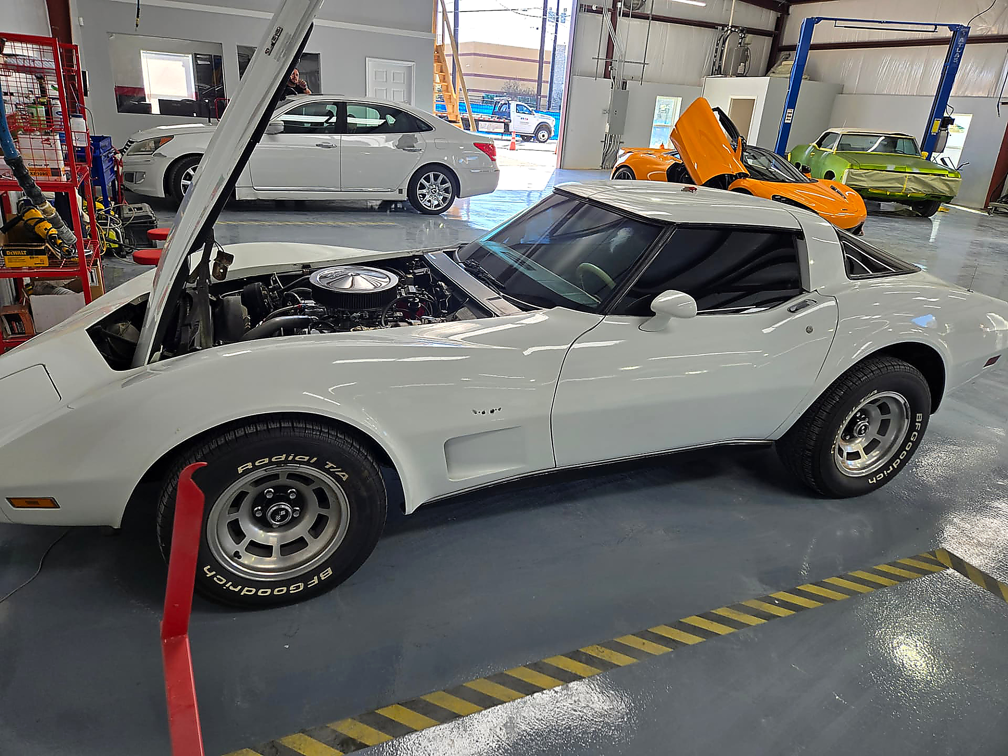 Classic white Corvette with hood open in the Rayco service bay